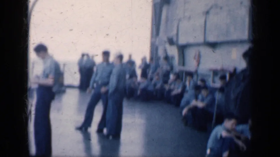 1962 Cuba home-movie frame showing uniformed crew members gathered on the deck of a naval vessel, with some standing and others seated.