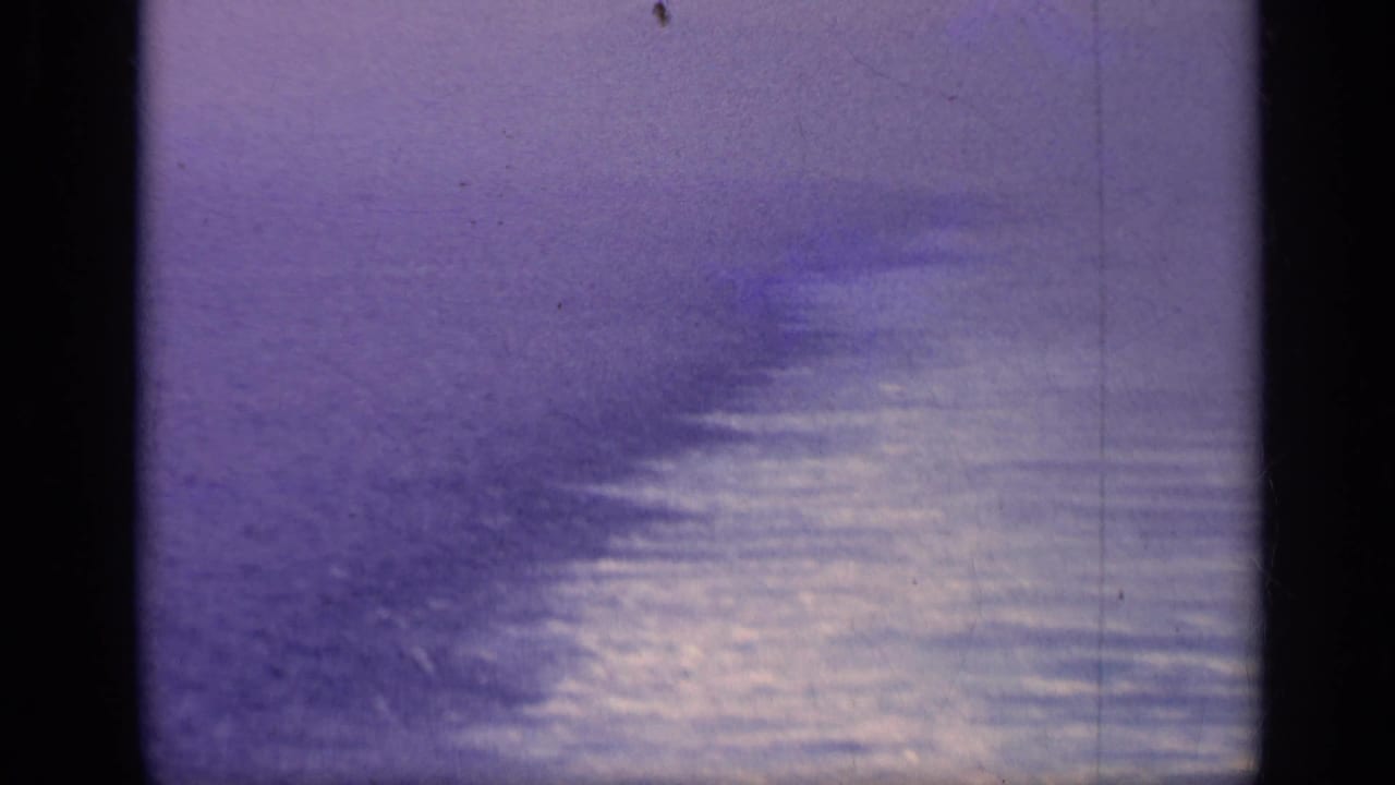 Open water with reflective patches and a hazy sky above the horizon.