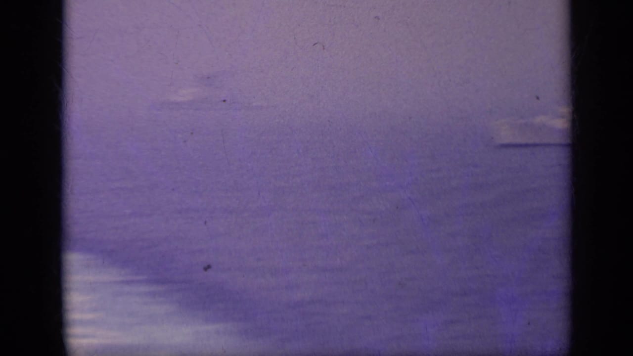 Open sea with a distant horizon and dark film-frame borders.
