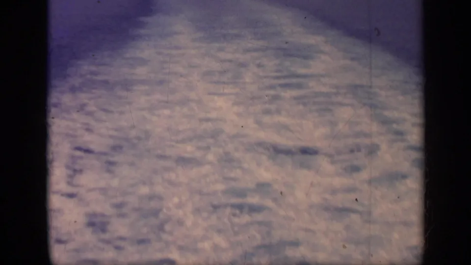 1962 Italy 8mm frame showing rippled ocean surface and a foamy wake viewed from a moving vessel.