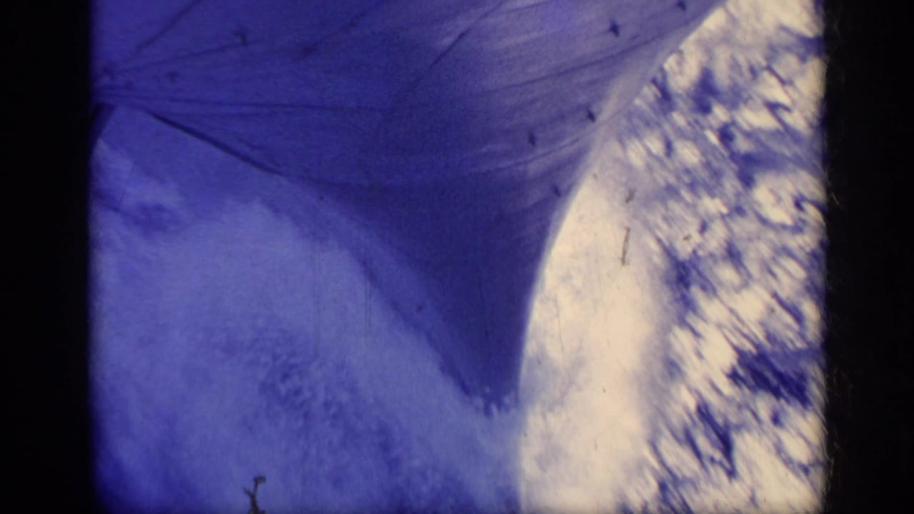 Blue-tinted close view of boat fabric or structure over bright foaming water.