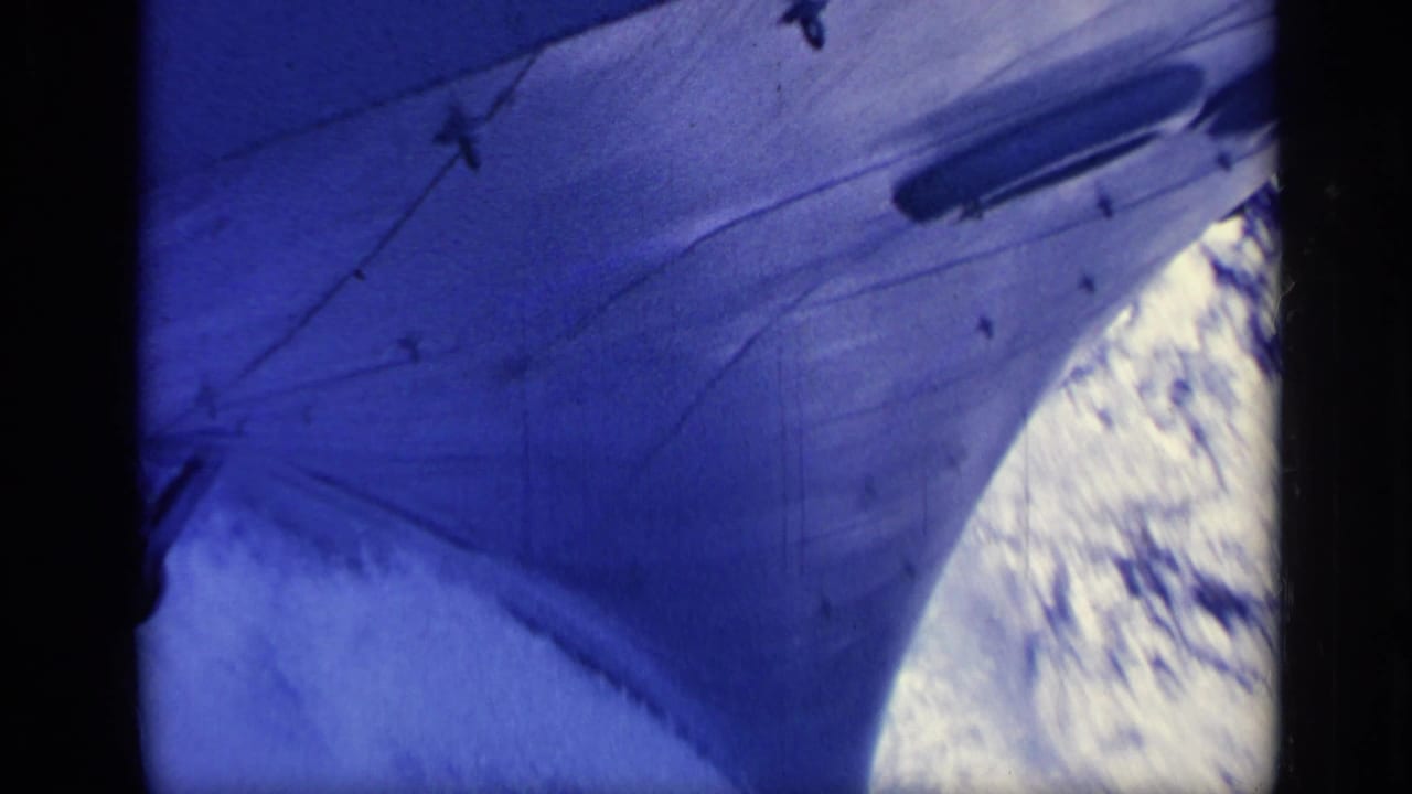 1962 Italy 8mm frame showing the forward hull and bow area of a ship beside bright ocean spray and dark framing.