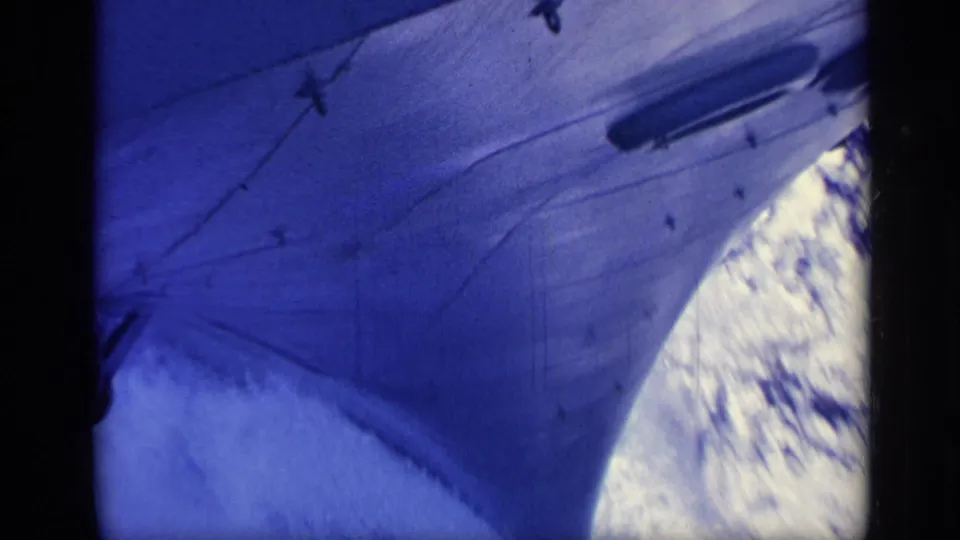 1962 Italy 8mm frame showing the forward hull and bow area of a ship beside bright ocean spray and dark framing.