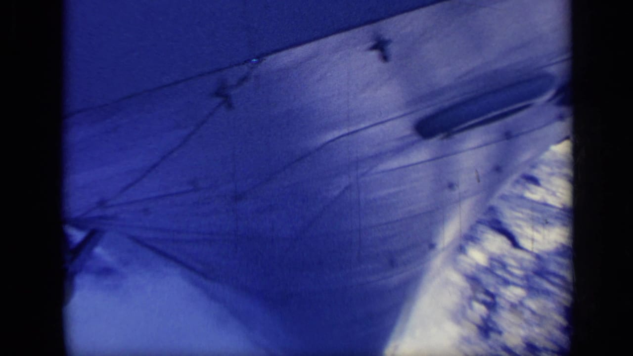 1962 Italy 8mm frame showing the ship side, blurred blue water, and wake along the hull.