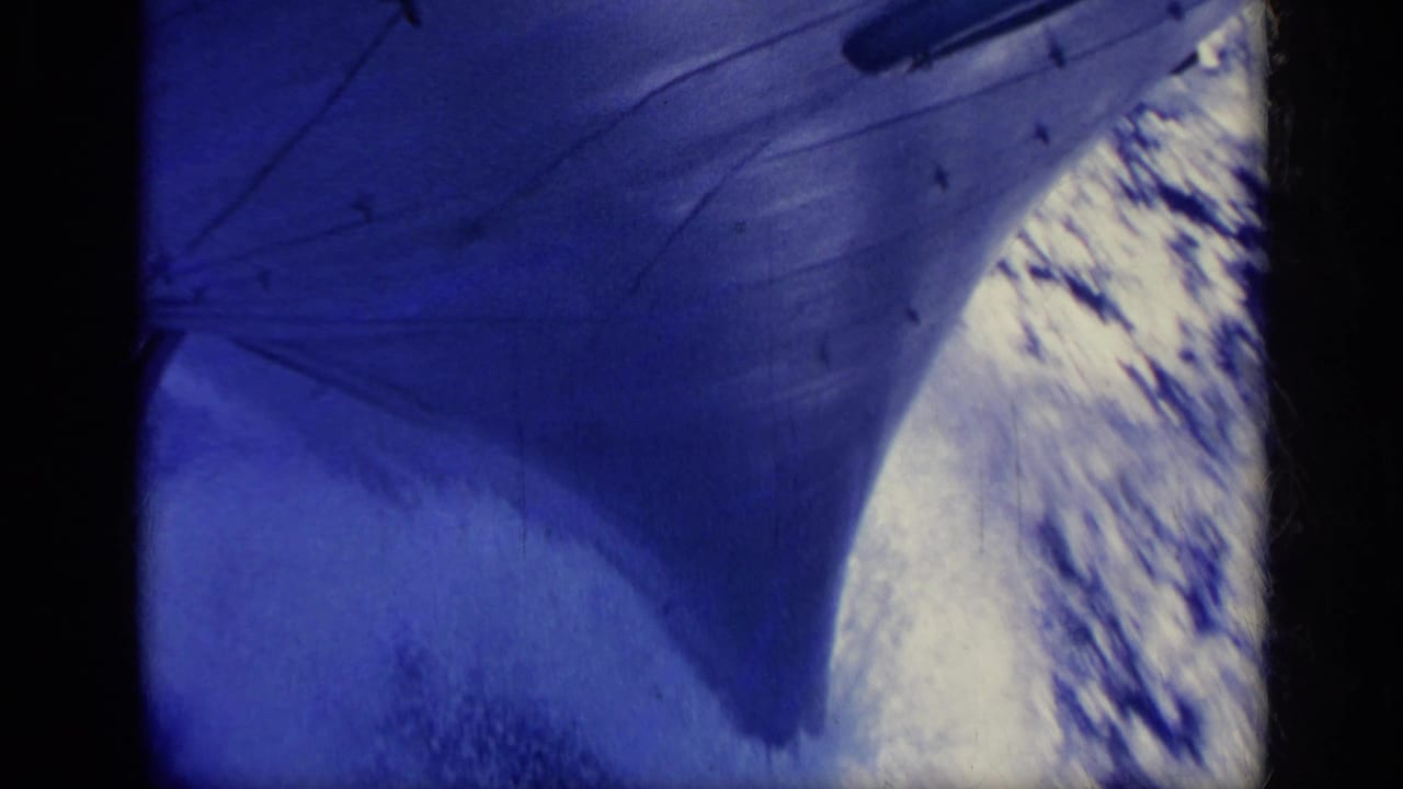 1962 Italy 8mm frame with a large ship hull edge and foaming blue-white water alongside.