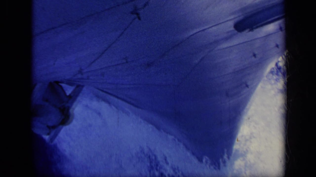 1962 Italy 8mm view from a vessel, with ship-side structure and wake-tinted blue water visible.