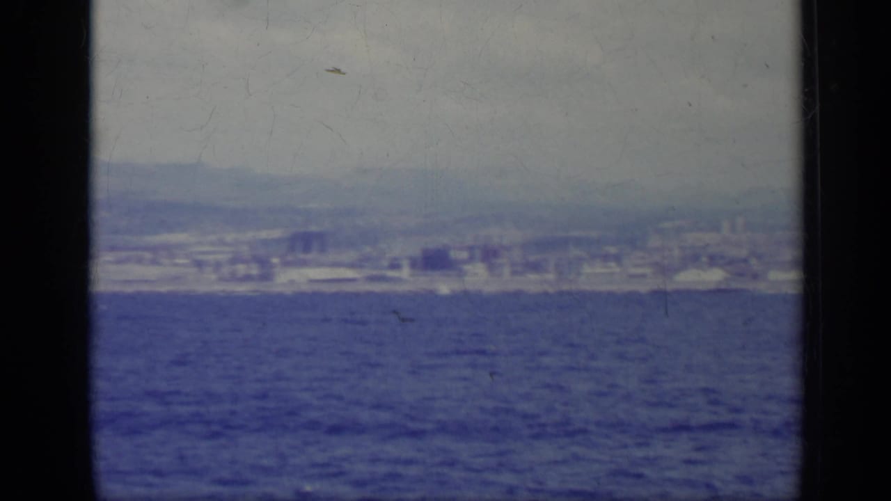 Wide sea view with distant shoreline buildings and mountains.