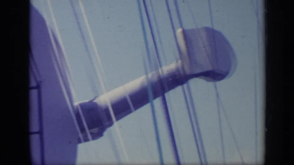 1962 Italy 8mm frame showing a large dish-like or funnel-shaped apparatus on a ship with vertical rigging lines.