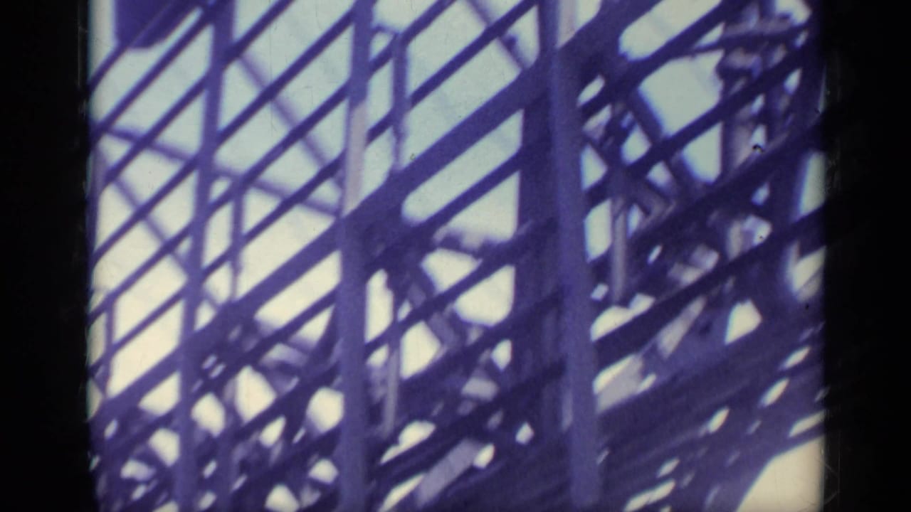 Low-angle view of ship framework and railings against a pale sky.