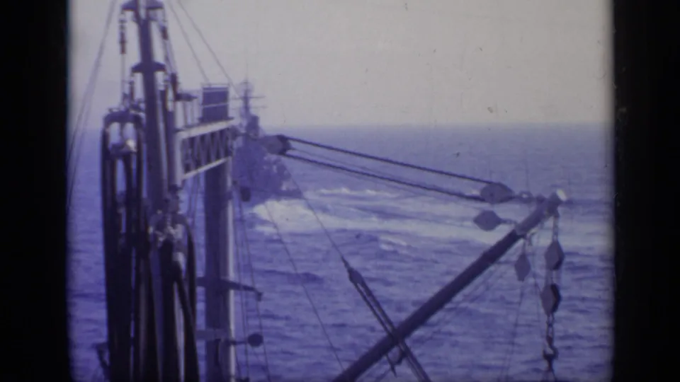 Shipboard view of superstructure, rigging, and crane lines over the ocean in 1962 Italy footage.
