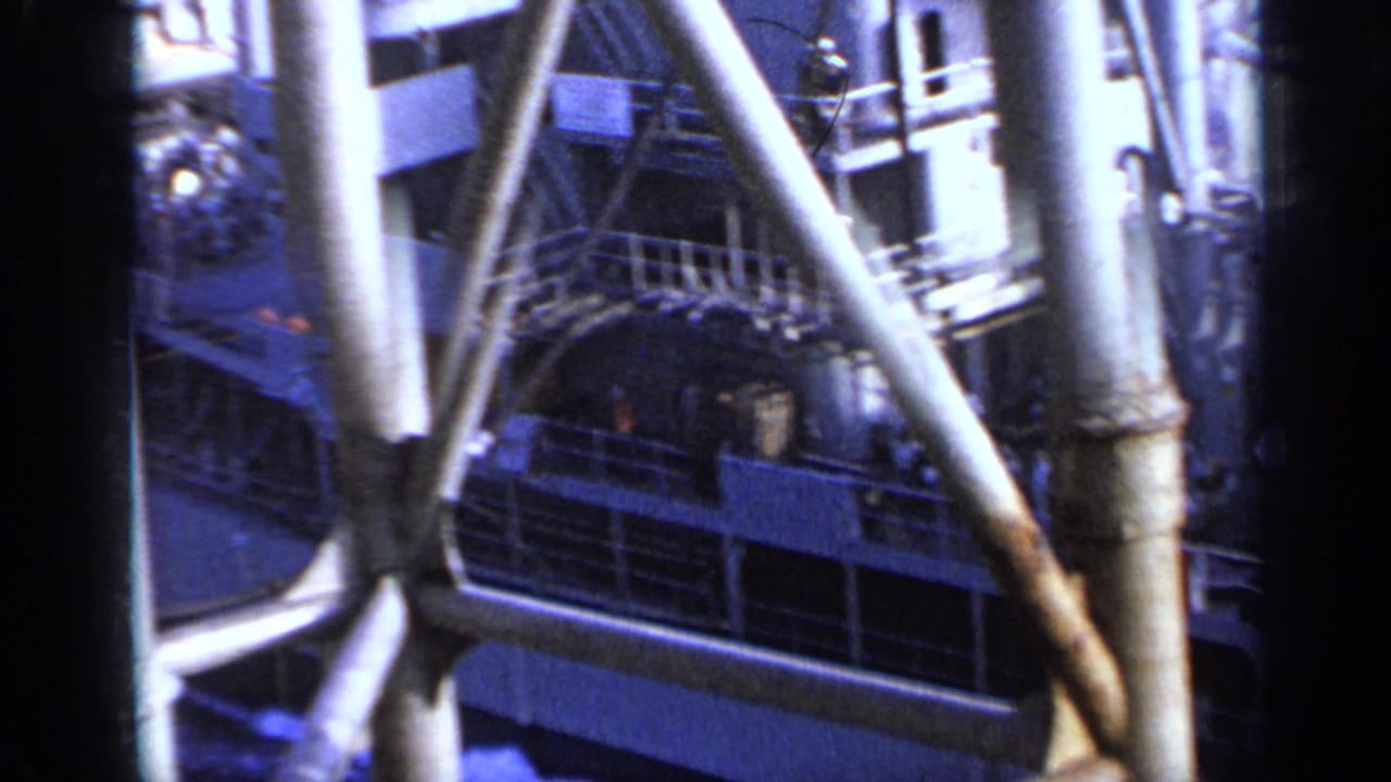 Ship deck and metal supports seen through another vessel's structure at sea.