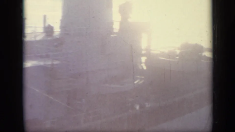 Soft 1962 Italy 8mm frame looking across shipboard equipment and rigging through haze and faded exposure.