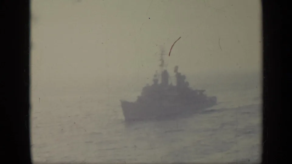 1962 Italy 8mm shot of a distant vessel moving across hazy open water, seen as a soft silhouette.
