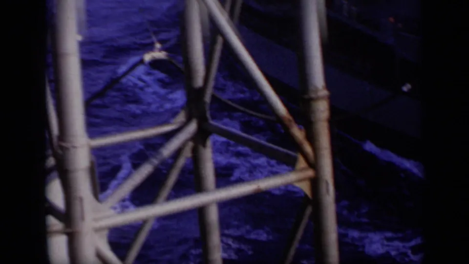 1962 Italy 8mm close view of metal rigging or davit supports with dark sea water visible below.