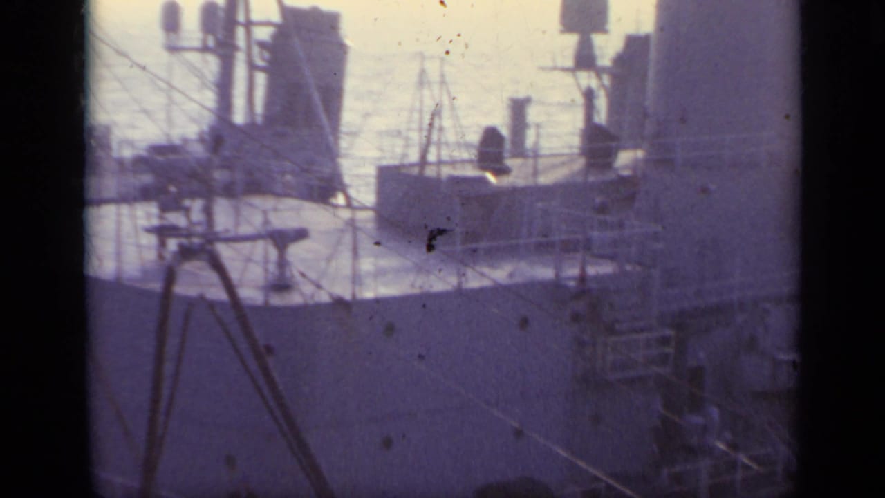 1962 Italy 8mm frame showing close views of a naval vessel's deck structures, railings, and equipment at sea.