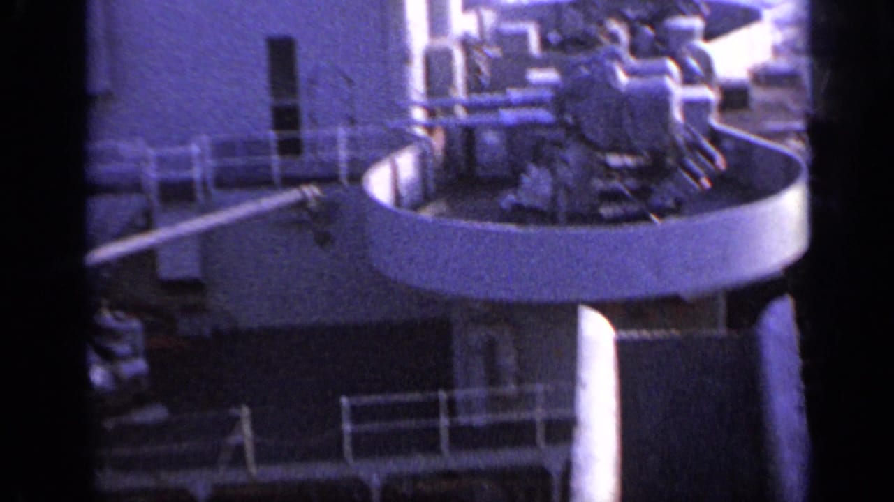 Passenger ship deck with lifeboat, railings, and small distant figures.