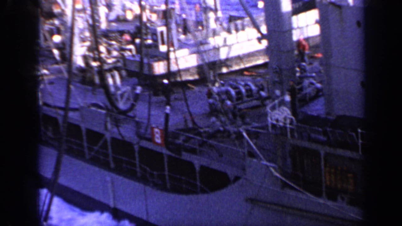 Large industrial vessel viewed from above, with deck equipment and blue water alongside.