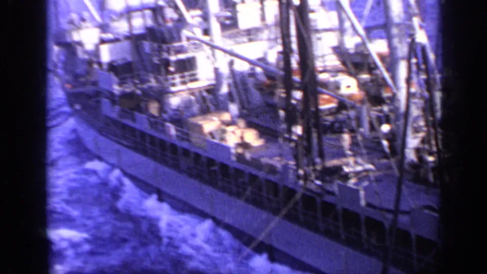 1962 Italy 8mm view across the side of a working vessel, with deck machinery, structural supports, and sea wake visible.