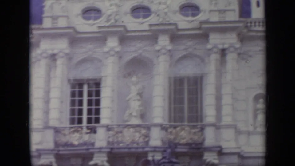 Historic Italian facade with carved figures, balcony railings, tall windows, and soft faded 8mm color.