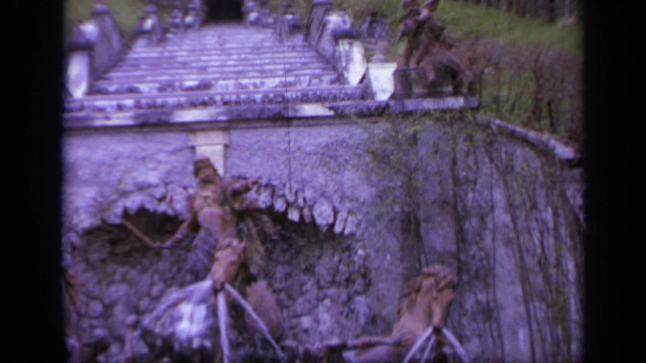 Stone staircase above an ornate fountain with sculptural figures and water spouts.