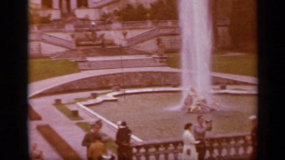 1962 Italy travel frame showing a broad fountain basin with a tall water jet and visitors gathered along the overlook.