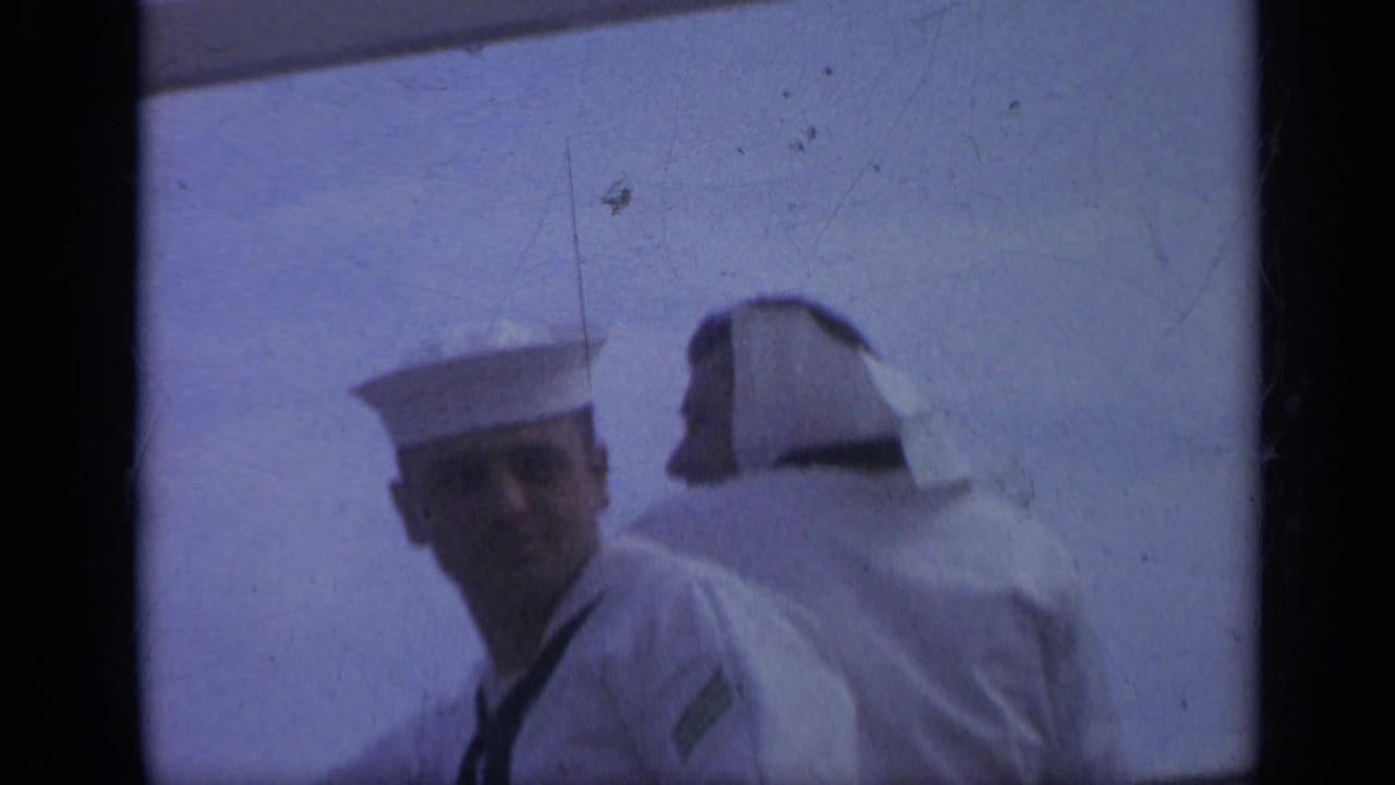 Two sailors on deck, with one face turned toward the camera.
