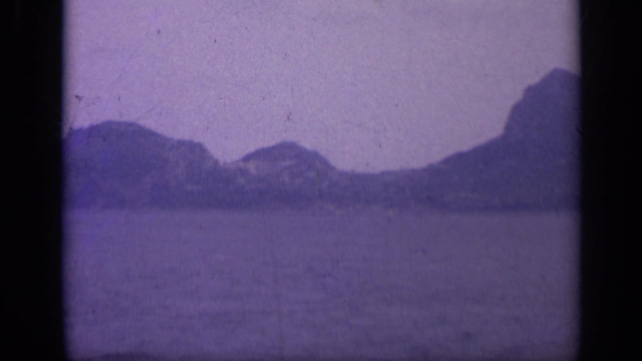 Open water facing distant rocky hills and shoreline silhouettes.