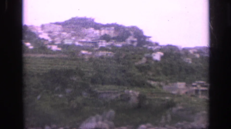 Italian coastal hillside village, likely from 1962 metadata, with white buildings set among terraced green slopes.