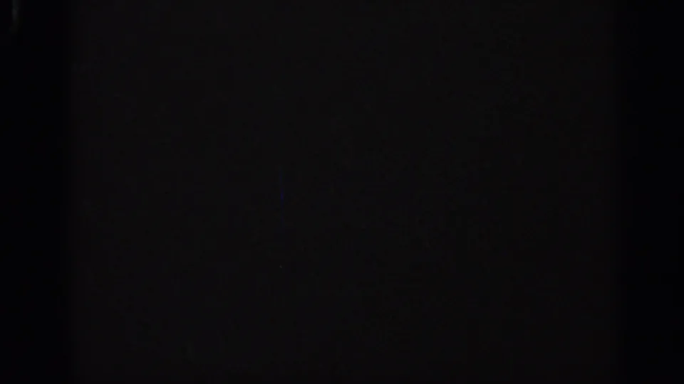 Very dark 1962 Italian 8mm frame with minimal visible detail, slight grain, and shadowed edges.