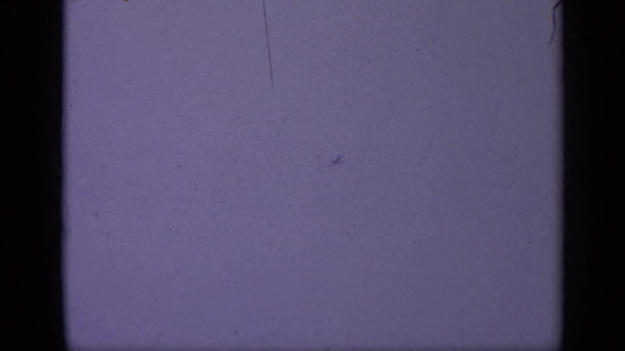 A partial 1962 Italy carrier-deck frame shows people near a naval jet, with the left side obscured by film edge and exposure.