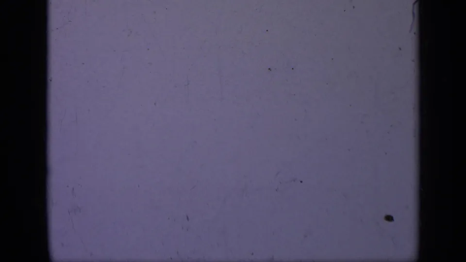 1962 Italy 8mm frame showing a purple-blue field with dark film borders, light grain, dust, and minor scratches.
