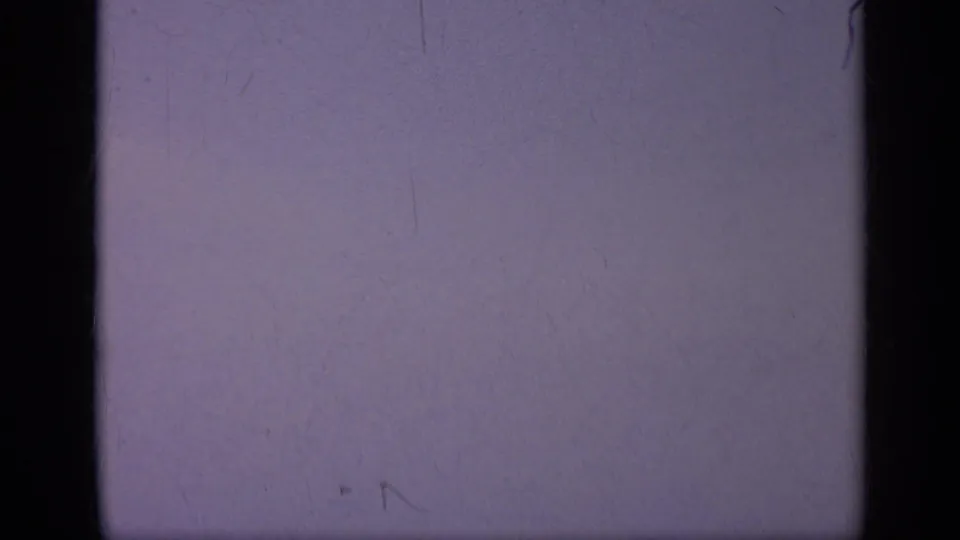 A mostly blank purple 8mm frame from the Italy 1962 clip, divided by dark film borders and marked by dust, scratches, and uneven exposure.