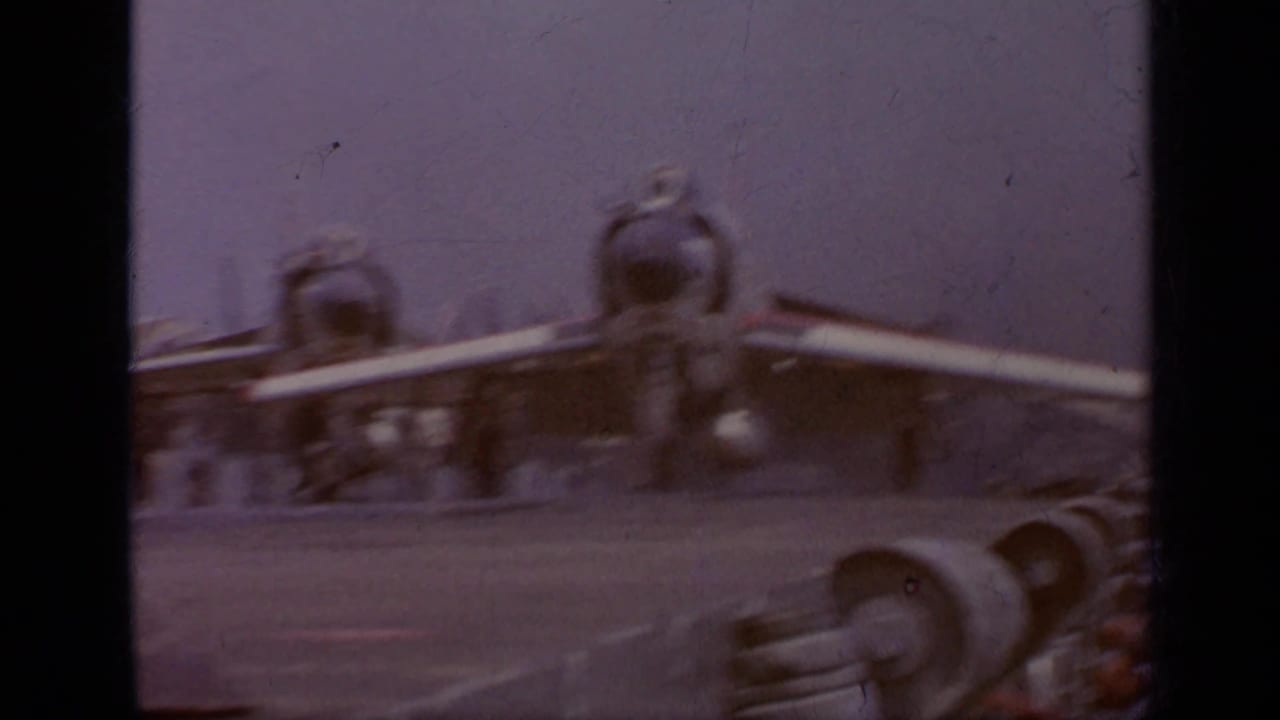 Blurred aircraft parts and carrier deck seen through an 8mm contact frame.