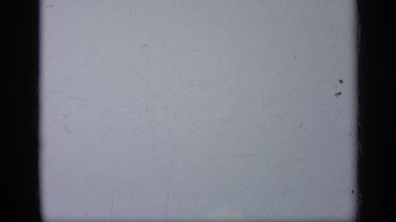 Mostly pale sky with dark film borders and no clear aircraft detail.