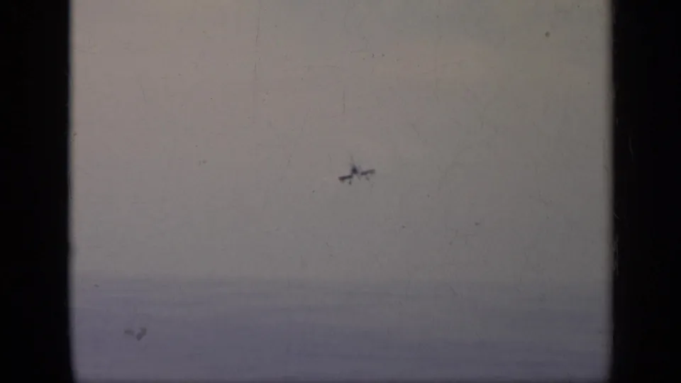 Distant aircraft appears over a hazy sky and horizon in this 1962 Italy aviation home-movie frame.
