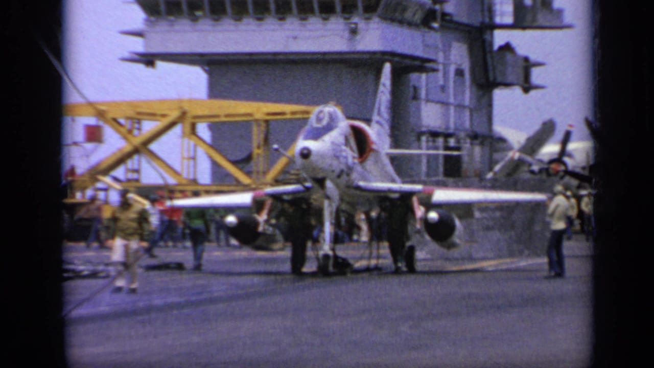 1962 Italy carrier-deck view of a military jet prepared for launch, with crew working around the aircraft.