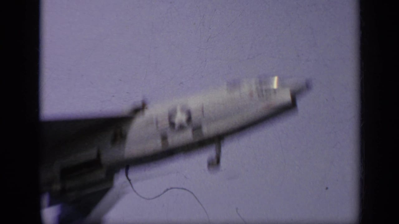 U.S. Navy jet moving across an aircraft carrier deck, seen in soft focus.