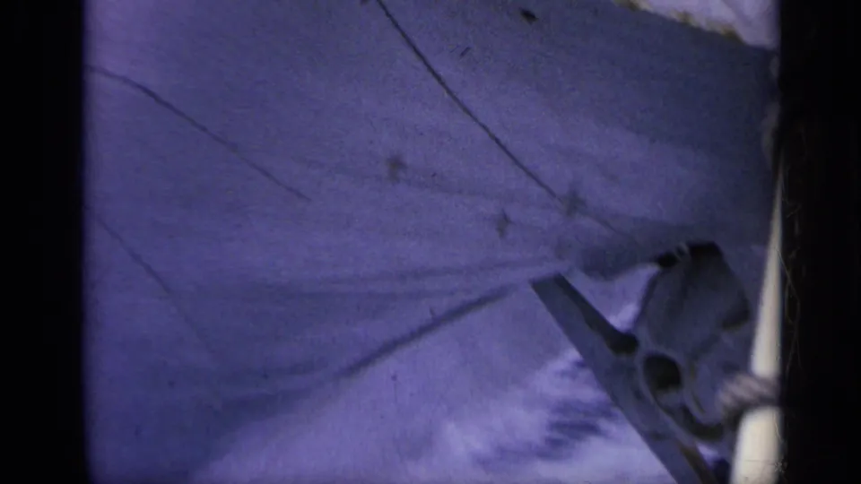 Handheld 8mm frame showing part of the boat surface, a small metal fitting, and surrounding wake during fast movement in Italy.
