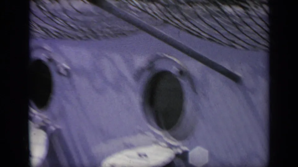 1962 Italy 8mm frame showing a close aircraft surface with circular openings, soft focus, grain, and dark frame edge.