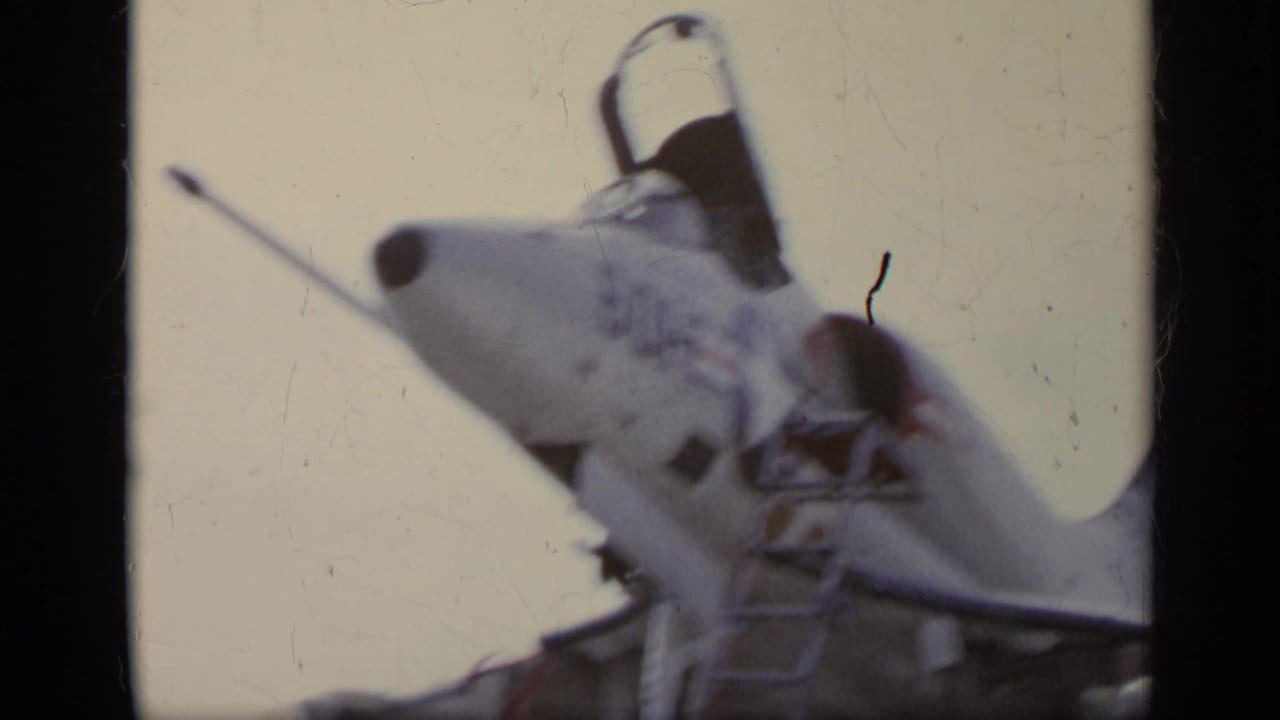 Low-angle view of a jet nose with cockpit canopy open.