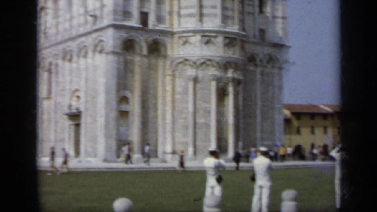 Cathedral stonework and Marines in white uniforms near the Pisa lawn.
