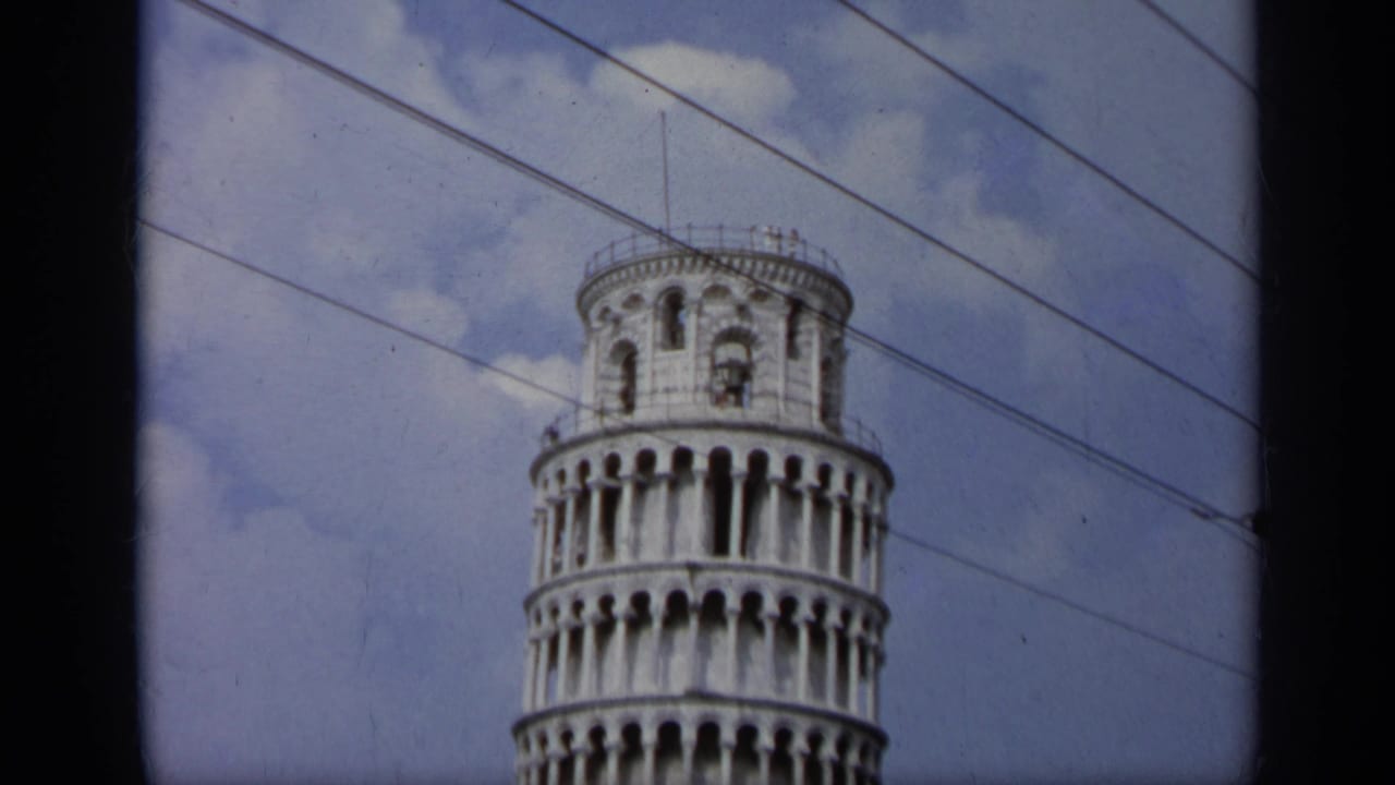 Upper section of the Leaning Tower of Pisa with overhead wires crossing the sky.