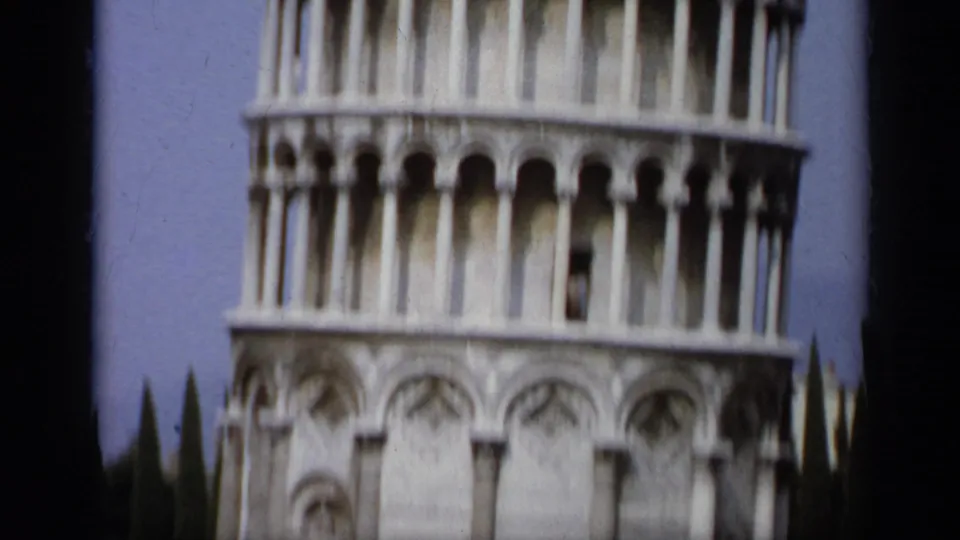 1962 8mm frame showing more of the Leaning Tower of Pisa, including lower blind arches and upper arcades.