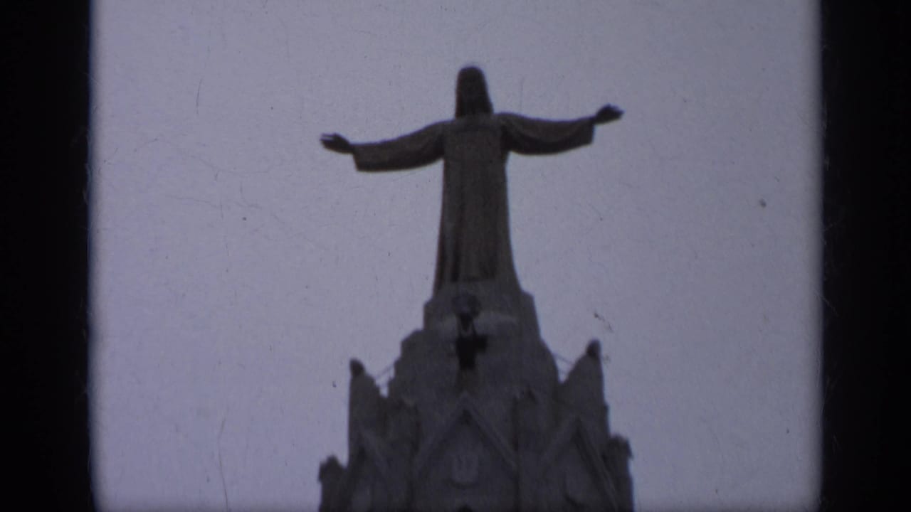 Closer view of a Christ statue standing above an ornate church tower.