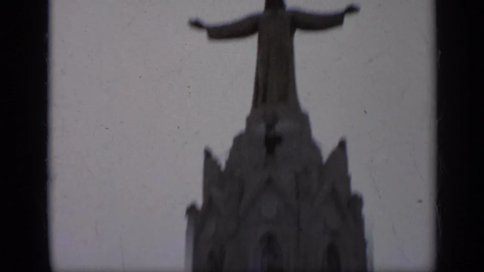 Soft 8mm frame from Italy in 1962 showing the upper church facade and Christ statue, filmed from a low tourist viewpoint.