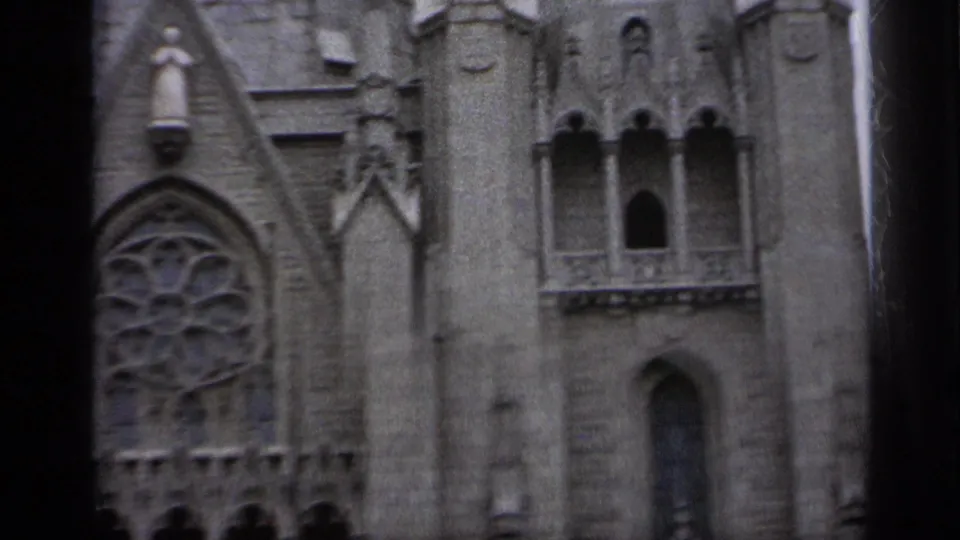 1962 Italy 8mm frame showing part of a large Gothic-style church facade with carved stonework, a rose window, and arched openings.
