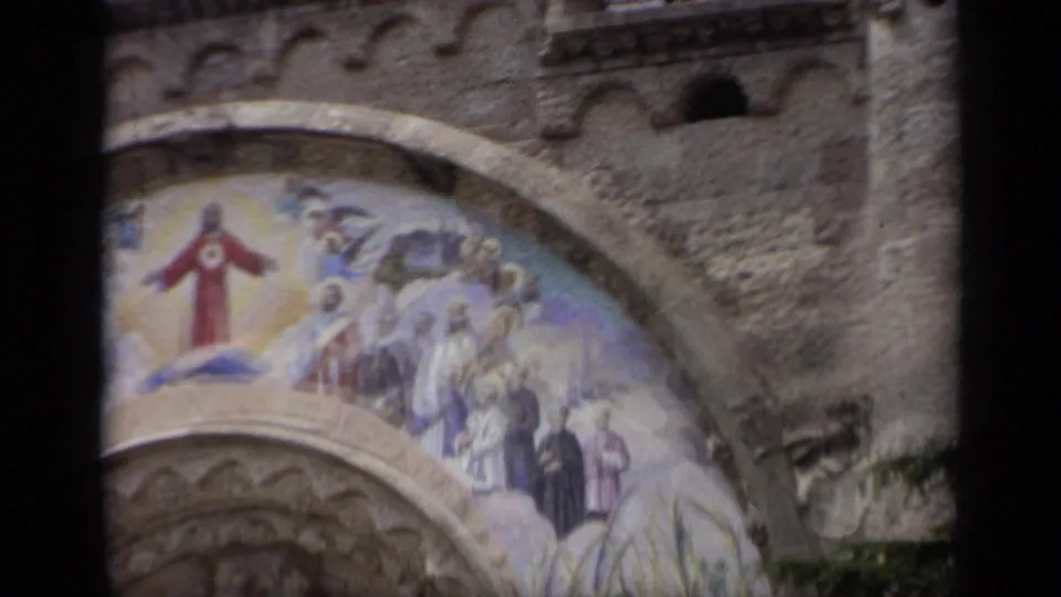 A closer passing view of the church fresco in Italy, showing Jesus Christ, surrounding figures, and the curved stone arch below.