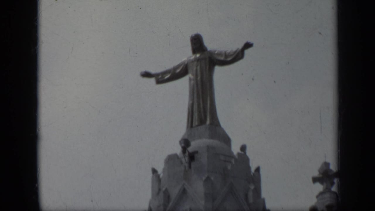 Similar low-angle view of the rooftop Jesus statue and cathedral top.