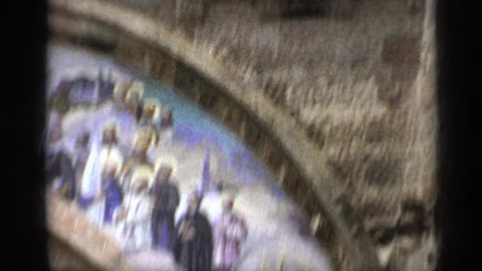 1962 Italy 8mm frame showing a close, soft view of stone arches and a colorful religious mosaic above a church entrance.