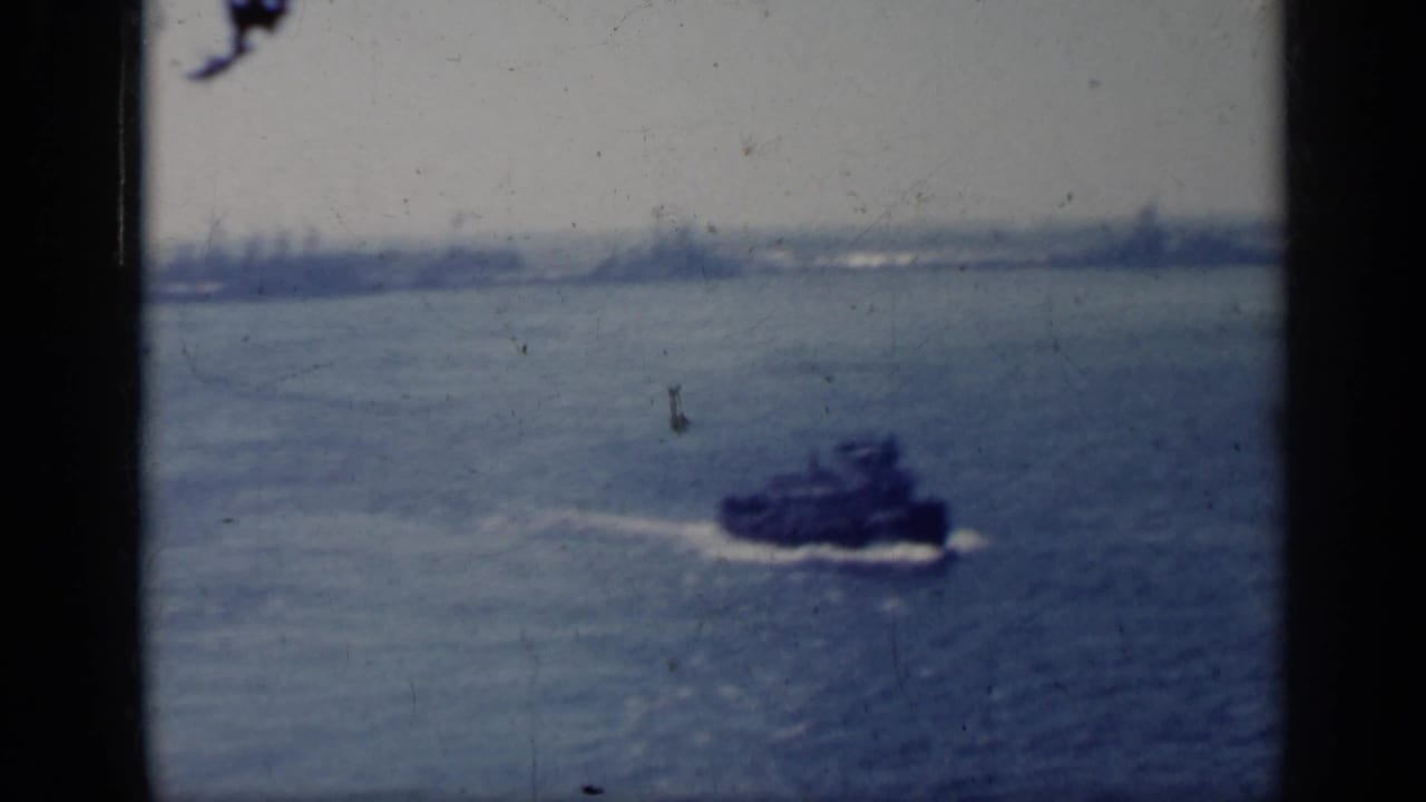 Small boat crossing choppy blue water with a hazy horizon beyond.